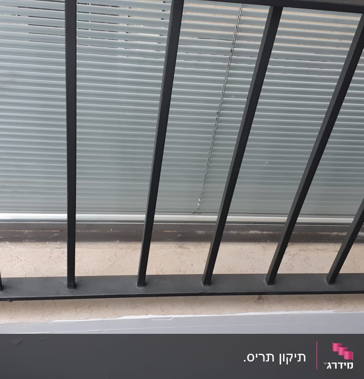 תריסים סגורים מאחורי סורגי מתכת שחורים